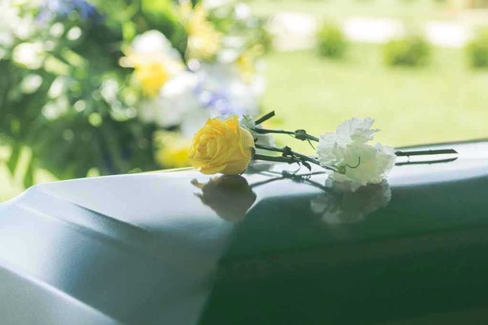 Yellow and white flowers on a green casket.
