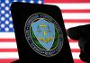 FTC logo on smartphone with American flag background.