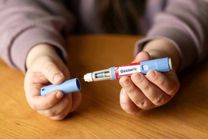2349255139. Hands holding an Ozempic injection pen.