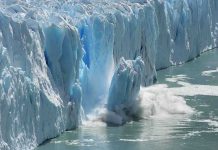 A glacier calving into the ocean, creating a splash of ice and water