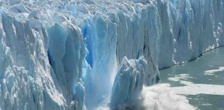 A glacier calving into the ocean, creating a splash of ice and water