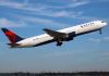 Delta Airlines airplane taking off against a blue sky
