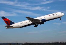 Delta Airlines airplane taking off against a blue sky