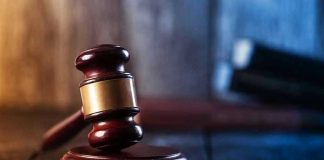 Asylum Seeker Trial STUNS – Shocking Report! Gavel on wooden table in dimly lit room.