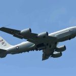 Hegseth’s Plane PLUMMETS 20,000 Feet – EMERGENCY Onboard! Military aircraft flying in clear blue sky.