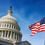U.S. Capitol building with American flag in foreground.