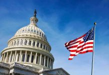 U.S. Capitol building with American flag in foreground.
