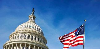 U.S. Capitol building with American flag in foreground.