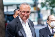 Man in suit and red glasses standing outside