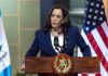Kamala Harris Shocker: Presidential Run Teased Person speaking at podium with flags in background.