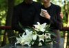 Yankees Prodigy Lost—Crash Stuns Baseball World Mourners in black holding white flowers at funeral.