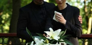 Yankees Prodigy Lost—Crash Stuns Baseball World Mourners in black holding white flowers at funeral.