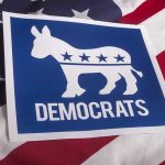Democratic Leader Endorses SOCIALIST — Party Implodes! Democrats logo on American flag background