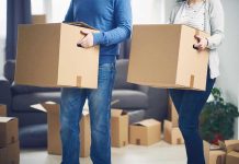 Exodus EXPOSED — Blue States Bleed Families Two people carrying cardboard boxes indoors.