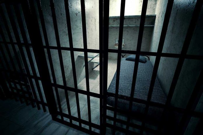 Interior view of a prison cell with a bed and metal bars