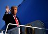 Trump Airport BREACHED – FBI Rush In! A political figure waving while standing on the steps of an aircraft