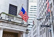 UNEXPECTED Inflation Collapse Triggers Market Frenzy Facade of the New York Stock Exchange with an American flag and Wall Street sign