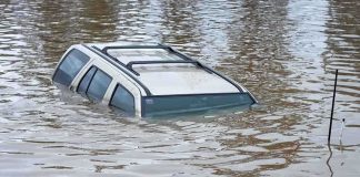 CATASTROPHIC Flooding – Thousands Displaced! A partially submerged vehicle in floodwaters