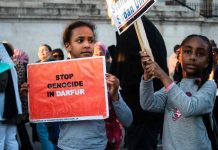 Children holding signs at a protest against Darfur genocide.