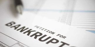 Deal COLLAPSES — Iconic Brands Spirals Towards Bankruptcy Petition for bankruptcy document with pen.