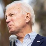 Biden Breaks Silence – Drops Trump BOMB! Man holding microphone, looking to the side.