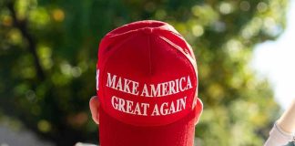 MAGA Labeled Racist – Professor FIRED Instantly Person wearing a red Make America Great Again hat.