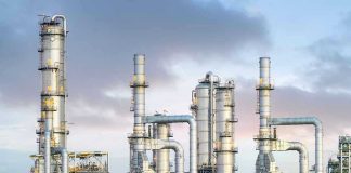 Toxic LEAK DEVASTATES Town — Dozens Hospitalized! Industrial plant with metal towers and pipes.