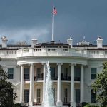 Drug Price CUT – Major Trump Deal White House with American flag and fountain, stormy sky.