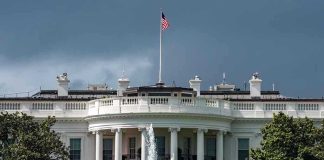 Drug Price CUT – Major Trump Deal White House with American flag and fountain, stormy sky.
