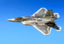Fighter jet in flight against a clear blue sky.