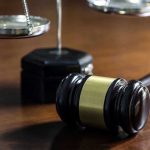 Trump DEFIES Federal Judge — Constitutional Crisis EXPLODES Gavel and scales of justice on wooden table.