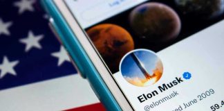 Smartphone displaying Twitter profile over American flag.