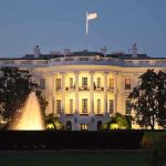 The White House illuminated at night with a fountain in the foreground