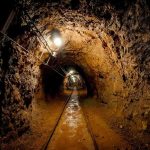 Flooded Mine Horror — Rescue Turns Deadly Dimly lit underground tunnel with rail tracks and rocky walls