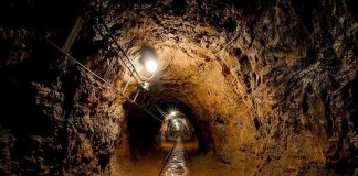 Flooded Mine Horror — Rescue Turns Deadly Dimly lit underground tunnel with rail tracks and rocky walls