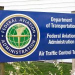 FAA Slashes Flights—Airports Spiral Into Turmoil Sign for the Federal Aviation Administration at an air traffic control tower