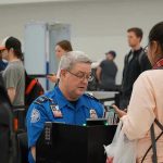Violent Assault SHOCKS Airport – TSA Agent Attacked, Officer STABBED! TSA agent checks passengers documents at airport security.