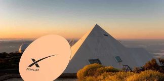 Satellite dish near pyramid-shaped building at sunset.