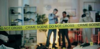 Elite Scientist Murder Shocks Secure Community Crime scene with tape and investigators examining evidence.