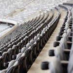 Empty rows of gray seats in a stadium.