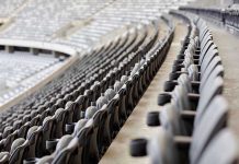 Empty rows of gray seats in a stadium.
