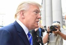 Trump DOZES During Peace Ceremony – Biden 2.0? Man in suit with photographers in background.