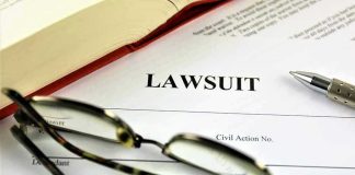 Lawsuit document with glasses, pen, and book.