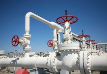 Trump’s Bold Oil Blockade Shocks Markets Industrial pipeline with red valves against a clear blue sky