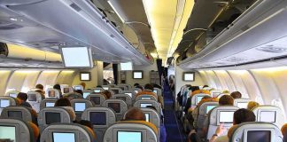 Tarmac Nightmare Spirals Into Insane Passenger Breakdown Interior view of an airplane with passengers seated and using in-flight entertainment screens