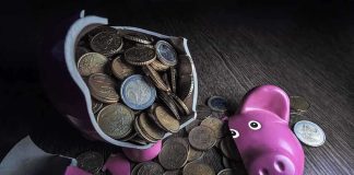 Hunter’s $15M Debt Bombshell Ignites Speculation A broken pink piggy bank with coins spilling out onto a wooden surface