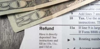 Massive 2026 Tax Refunds Shocking Americans Close-up of tax refund form with cash on a wooden surface