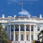 White House Sparks Fury Using Pop Star’s Song The White House with the American flag flying against a blue sky