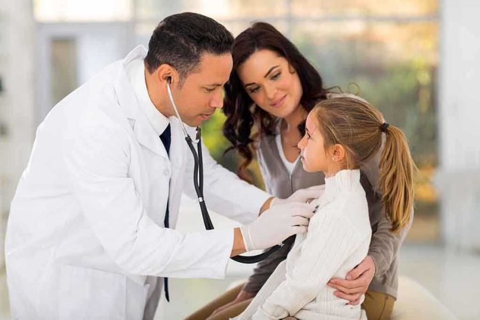shutterstock_212705374.jpg A doctor examines a young girl with a stethoscope while her mother watches