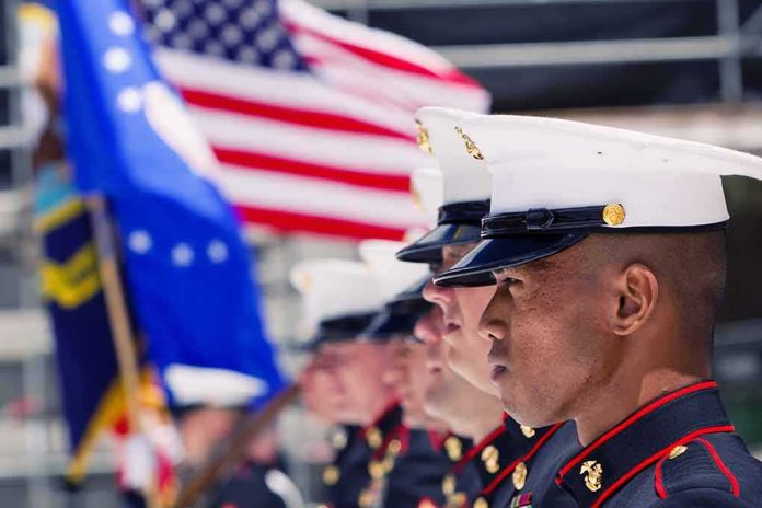 Marines in uniform standing in formation with flags in the background